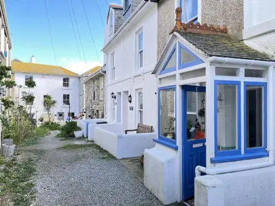 a house with a blue door on a street at Sea Pebble a characterful fisherman cottage in St Ives