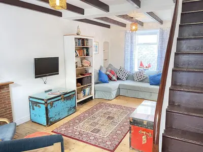 a living room with a couch and a tv at Sea Pebble a characterful fisherman cottage in St Ives