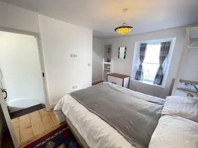 a bedroom with a large bed and a window at Sea Pebble a characterful fisherman cottage in St Ives