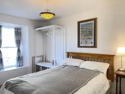 a bedroom with a bed and a window at Sea Pebble a characterful fisherman cottage in St Ives