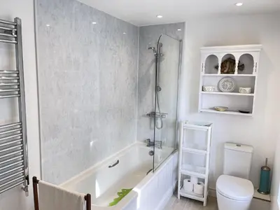 a bathroom with a tub and a toilet and a shower at Sea Pebble a characterful fisherman cottage in St Ives