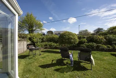two chairs sitting in the grass in a yard at 3 Menague in Padstow