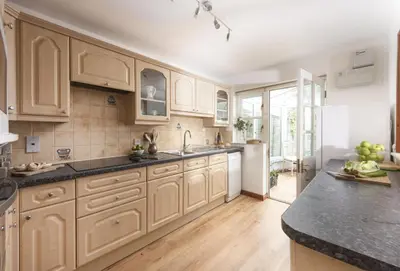 a kitchen with white cabinets and a black counter top at 3 Menague in Padstow