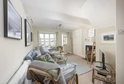 a living room with a blue couch and a fireplace at Aloe Cottage in Padstow
