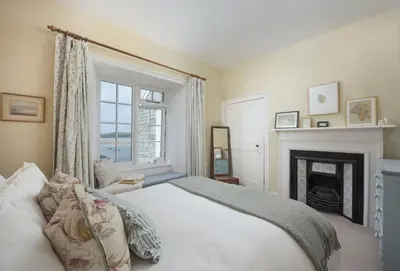 a bedroom with a bed and a fireplace at Aloe Cottage in Padstow