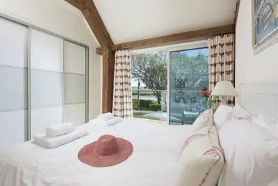 a large white bed with a straw hat on it at Gull Rock in Padstow