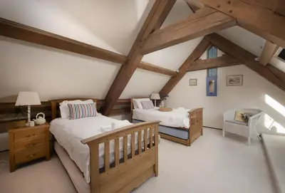 a attic bedroom with two beds and a crib at Gull Rock in Padstow