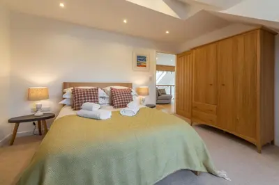 a bedroom with a large bed with towels on it at Highcroft in Saint Minver
