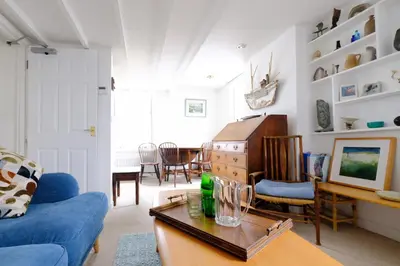 a living room with a blue couch and a table at 4 Victoria House with the best views in St Ives in St Ives