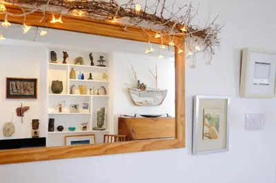 a mirror in a room with vases on shelves at 4 Victoria House with the best views in St Ives in St Ives