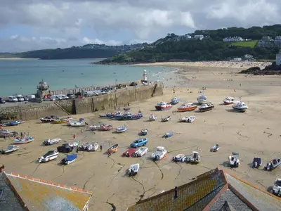 a group of cars parked on a beach near the water at 4 Victoria House with the best views in St Ives in St Ives