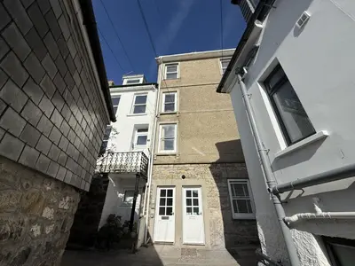 a building with a white door in a alley at 4 Victoria House with the best views in St Ives in St Ives