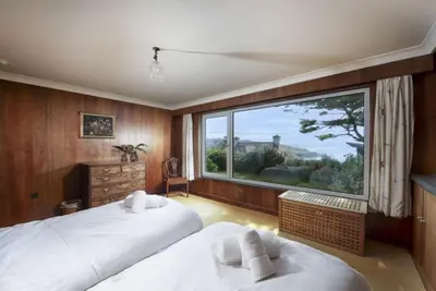 a bedroom with two beds and a large window at Rabbit Hill in Polzeath
