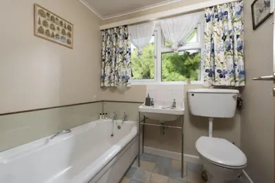 a bathroom with a tub and a toilet and a sink at Rabbit Hill in Polzeath