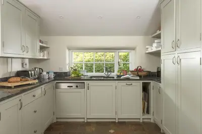 a kitchen with white cabinets and a window at Sparnal Stitch in Padstow