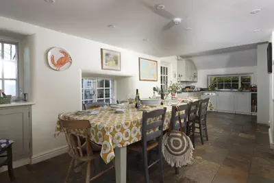 a kitchen with a table and chairs in a room at Sparnal Stitch in Padstow
