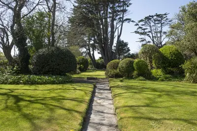 a walkway in a garden with grass and bushes at Sparnal Stitch in Padstow