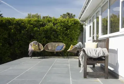 a patio with chairs and tables on a house at Tresevens in Polzeath