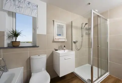 a bathroom with a shower and a toilet and a sink at Tresevens in Polzeath