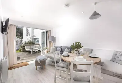 a dining room and living room with a table and chairs at Robin in Polzeath