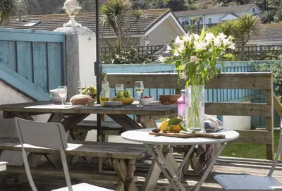 a picnic table with a vase of flowers on it at Robin in Polzeath
