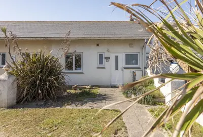 a small white house with a yard at Robin in Polzeath