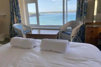 a bedroom with a bed with a view of the ocean at Trevose View in Polzeath