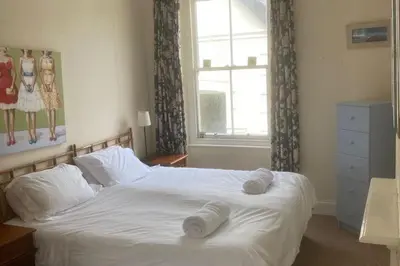 a bedroom with a white bed with towels on it at Trevose View in Polzeath