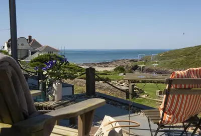 a porch with a bench and a view of the ocean at The Perch Studio in Polzeath