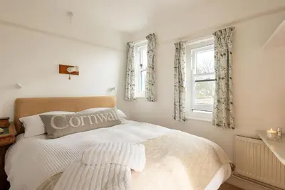 a bedroom with a white bed and a window at Trerair in Saint Minver