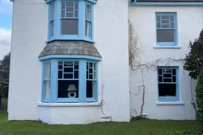 a house with a blue window on the side of it at Trerair in Saint Minver