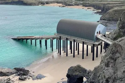 a pier on a beach next to the water at Trerair in Saint Minver