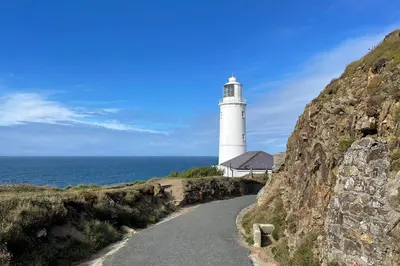 a lighthouse on a hill next to the ocean at Trerair in Saint Minver