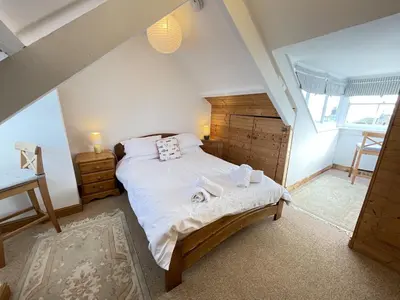 a bedroom with a large bed in a attic at Silver Seahorse a classic fishermans cottage in St Ives