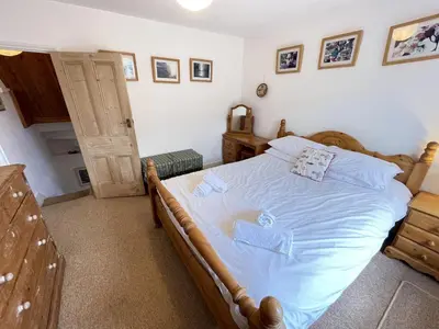 a bedroom with a bed with blue sheets at Silver Seahorse a classic fishermans cottage in St Ives