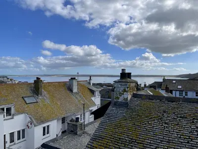 a view of roofs of buildings and a body of water at Silver Seahorse a classic fishermans cottage in St Ives