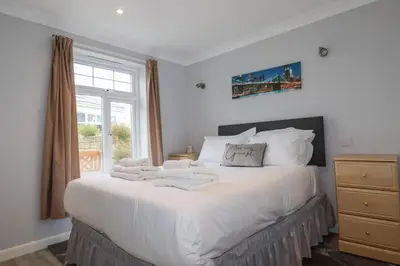 a bedroom with a large white bed with towels on it at Satinwood in Newquay