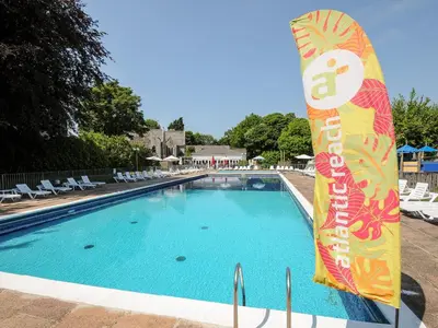 a swimming pool with a sign in the middle at Satinwood in Newquay