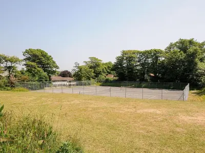 a tennis court in the middle of a field at Satinwood in Newquay