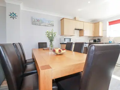 a dining room table with a bowl of fruit on it at Satinwood in Newquay