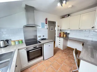 a kitchen with white cabinets and a stove top oven at The Nest in St Ives