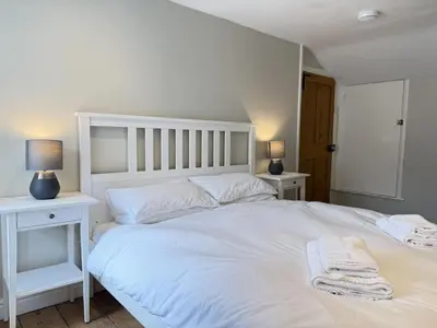 a bedroom with a large white bed with two night stands at The Nest in St Ives