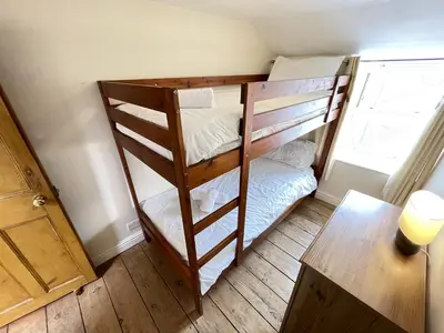 a room with two bunk beds and a table at The Nest in St Ives