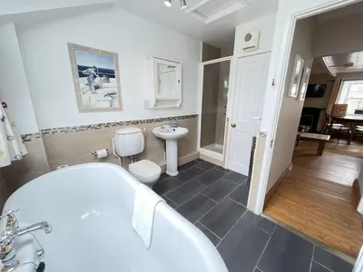 a bathroom with a tub and a toilet and a sink at The Nest in St Ives
