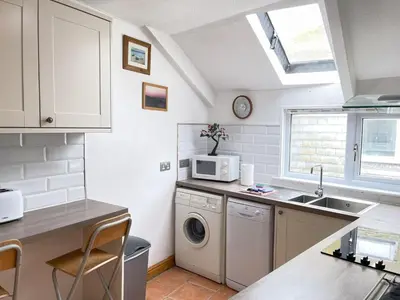 a kitchen with a sink and a washing machine at The Nest in St Ives