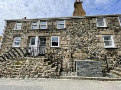 an old stone house with a brick wall at The Nest in St Ives