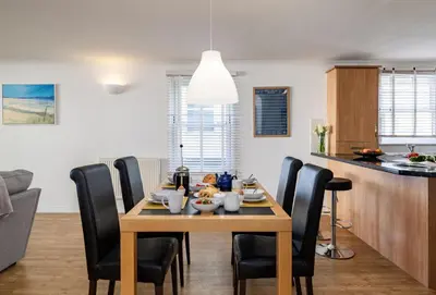 a dining room and kitchen with a table and chairs at 8 Spinnakers in Fistral, Newquay in Newquay