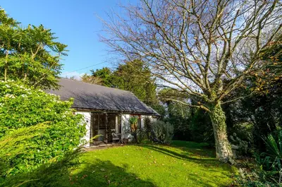 a small cottage with a tree in the yard at Shilbury Retreat Cottage near Perranporth in Perranporth