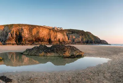 a rock in the sand on a beach at Shilbury Retreat Cottage near Perranporth in Perranporth