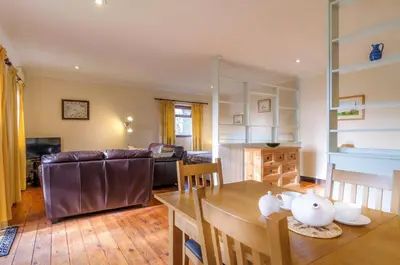 a living room with a table and a couch at Shilbury Retreat Cottage near Perranporth in Perranporth